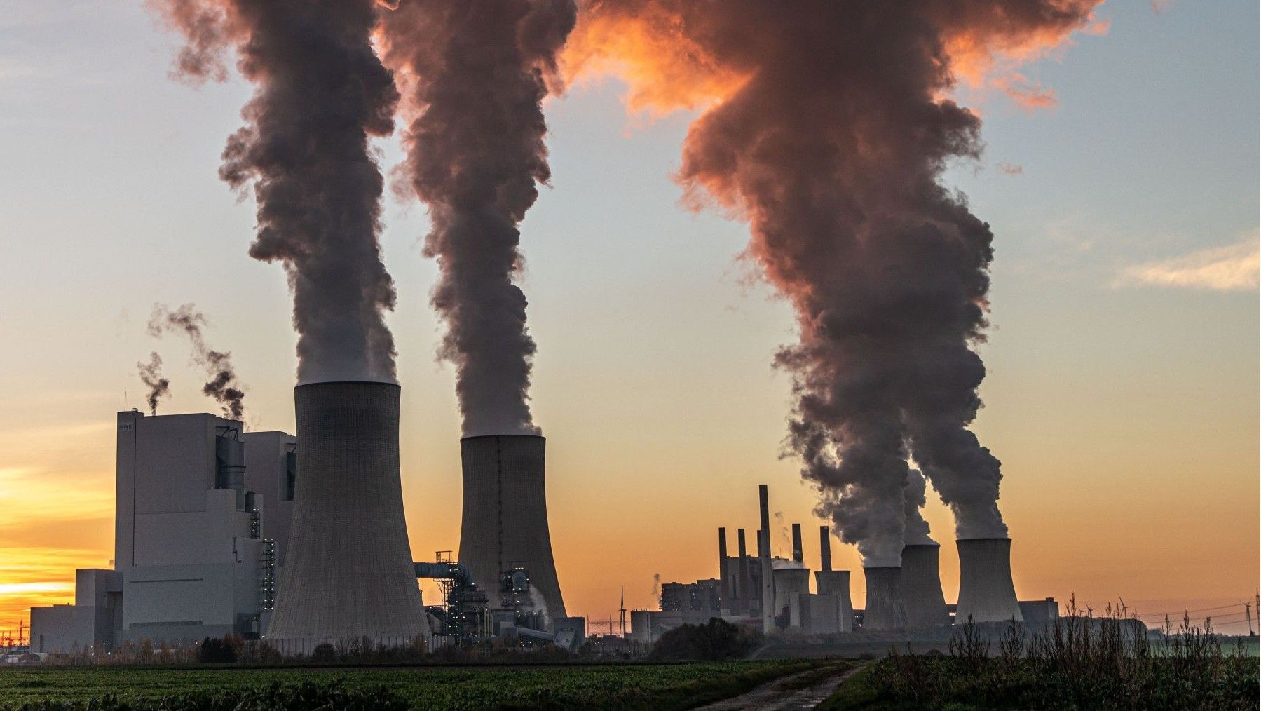 Instalación industrial con chimeneas, vinculada a las emisiones de CO2 atmosférico.