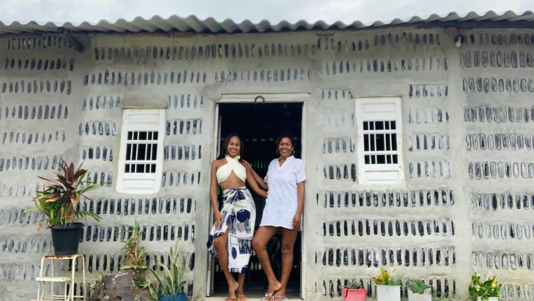 Edna y Gabrielly Dantas en la puerta de la Casa de Sal, construida con botellas de vidrio en Itamaracá, Brasil