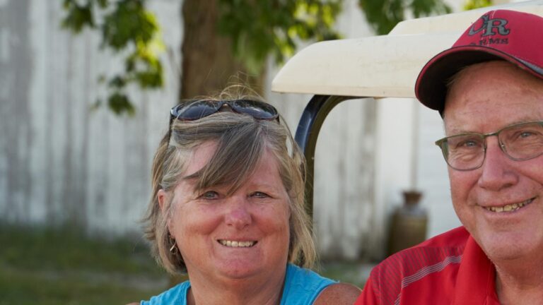 Clayton Rosenberger y su mujer junto a un aerogenerador en su granja de Illinois