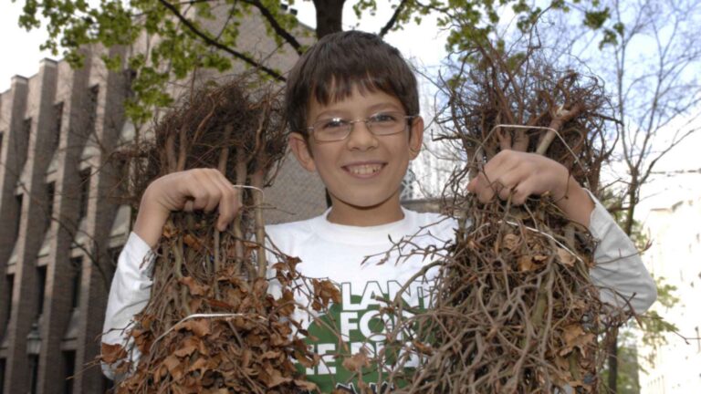 Felix Finkbeiner de niño sostiene dos haces de plantones, origen de la campaña por un billón de árboles