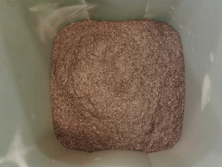 Sustrato de cultivo de color pardo obtenido a partir de restos de posidonia triturados, dentro de un recipiente