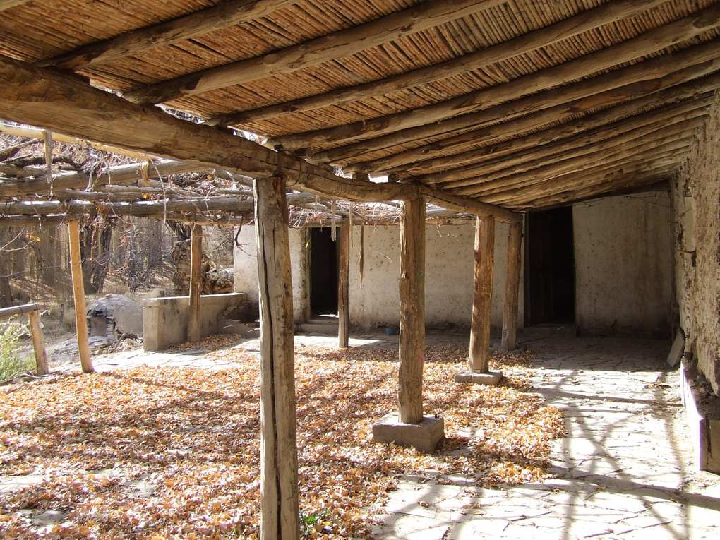 Galería con techo de caña y postes de madera en el casco de la antigua estancia El Leoncito