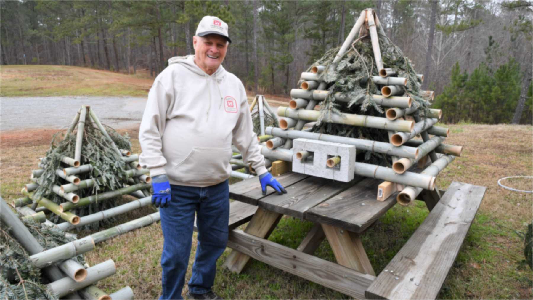 Jimmy Moore junto a una pirámide de bambú con árboles de Navidad para el lago Allatoona