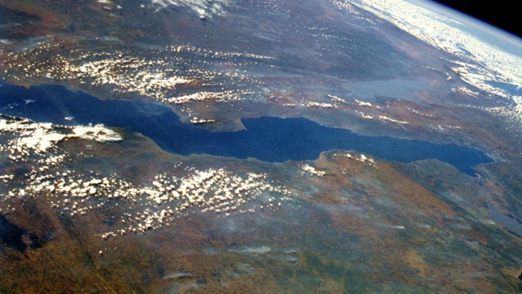 El lago Tanganica visto desde el transbordador espacial como una larga franja azul entre tierras rojizas de África oriental