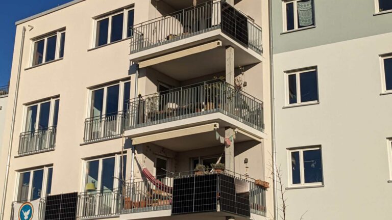 Paneles solares de balcón colgados de las barandillas de un bloque de viviendas en Alemania