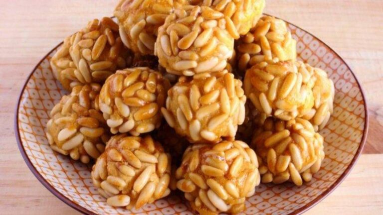 Panellets ecológicos de almendra y patata cubiertos de piñones dorados.