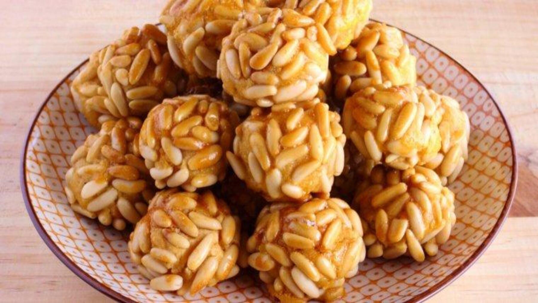 Panellets ecológicos de almendra y patata cubiertos de piñones dorados.