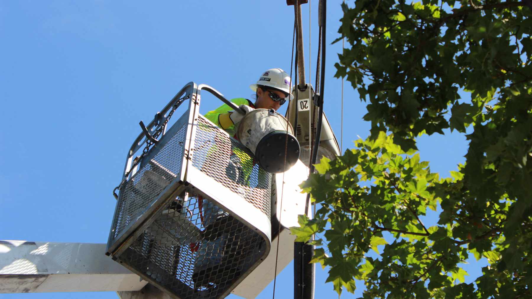 Un operario de Portland cambia una farola por una luminaria LED desde una cesta elevadora